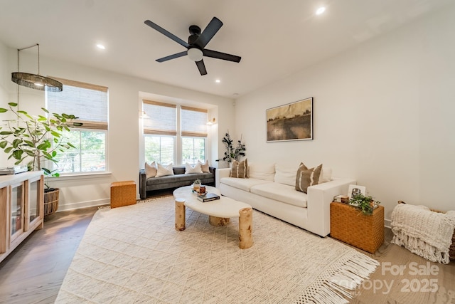 living area with a ceiling fan, recessed lighting, wood finished floors, and baseboards