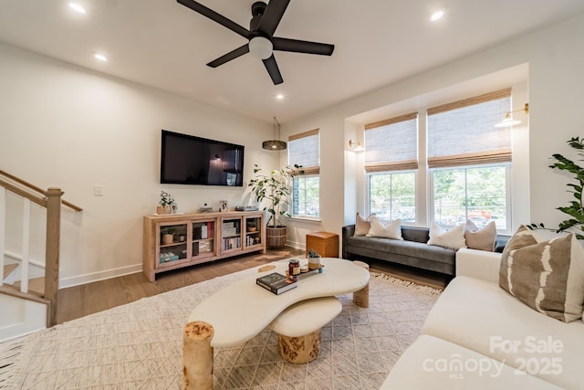 living area with recessed lighting, stairs, and wood finished floors