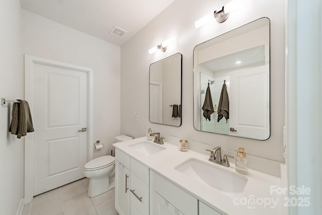 bathroom featuring double vanity, visible vents, toilet, and a sink