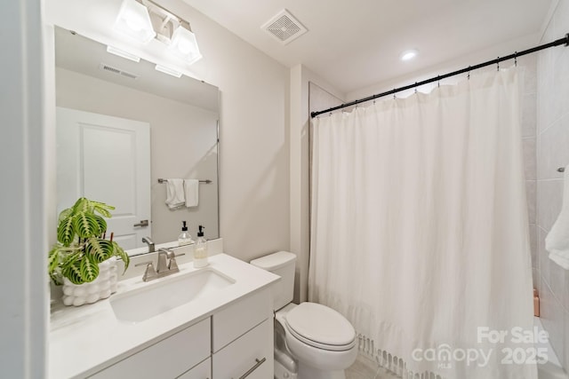 bathroom featuring vanity, a shower with shower curtain, toilet, and visible vents