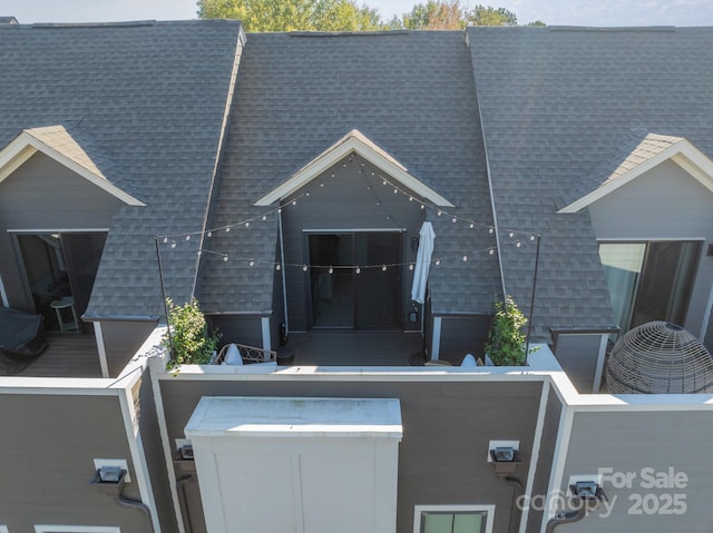 exterior space featuring roof with shingles