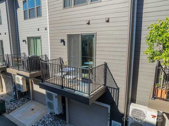 wooden terrace featuring ac unit and an attached garage