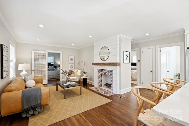 living room with a fireplace, hardwood / wood-style flooring, and crown molding