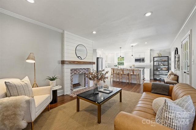 living room featuring light hardwood / wood-style floors, crown molding, and a fireplace