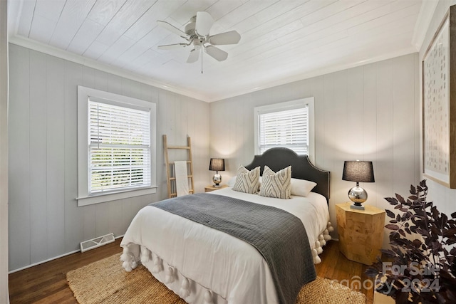 bedroom featuring ceiling fan, wood walls, dark hardwood / wood-style flooring, and crown molding