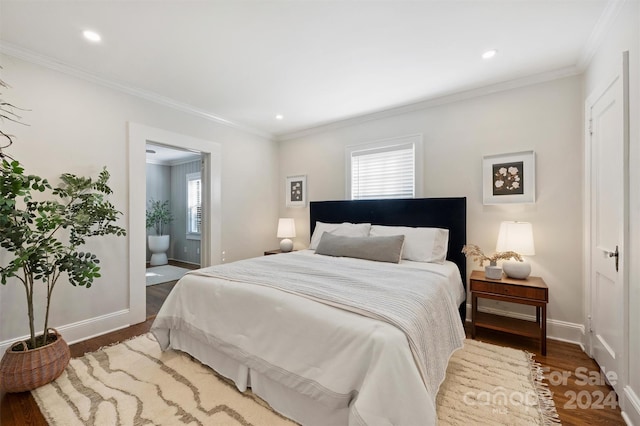 bedroom with dark hardwood / wood-style flooring, ensuite bathroom, multiple windows, and ornamental molding