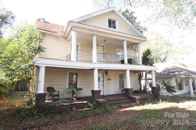 neoclassical home with covered porch and a balcony