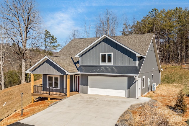 view of front facade featuring a shingled roof, a standing seam roof, metal roof, a garage, and driveway