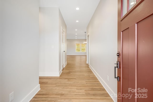 corridor featuring recessed lighting, baseboards, and light wood finished floors