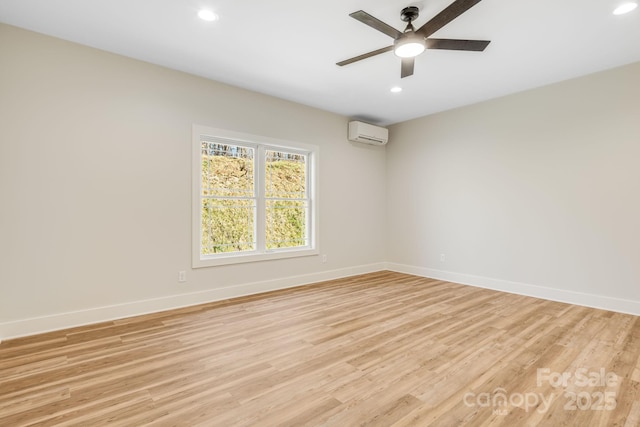 unfurnished room featuring light wood-type flooring, recessed lighting, a wall mounted air conditioner, and baseboards