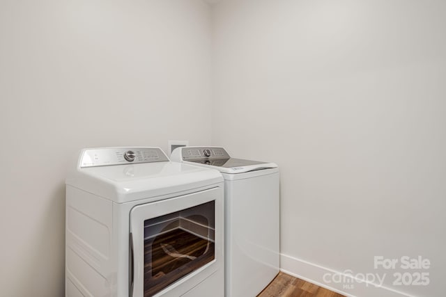 clothes washing area featuring laundry area, baseboards, separate washer and dryer, and light wood-style floors