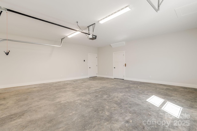 garage featuring a garage door opener and baseboards