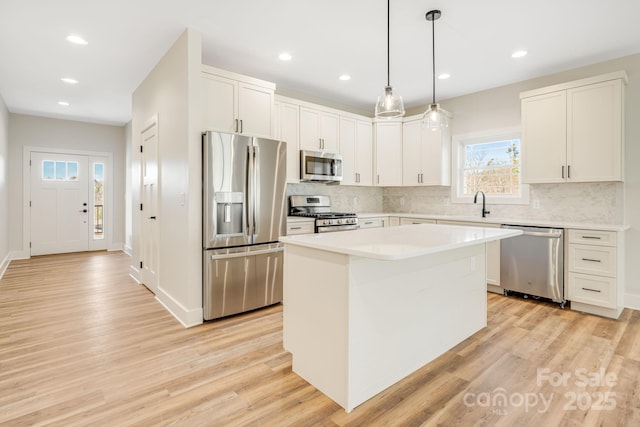 297 Bethany Dr, Mars Hill, NC 28754 - kitchen with appliances with stainless steel finishes, light wood-style floors, a kitchen island, decorative backsplash, and recessed lighting