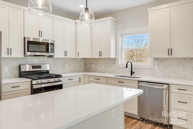 297 Bethany Dr, Mars Hill, NC 28754 - kitchen featuring stainless steel appliances, a sink, light countertops, tasteful backsplash, and decorative light fixtures