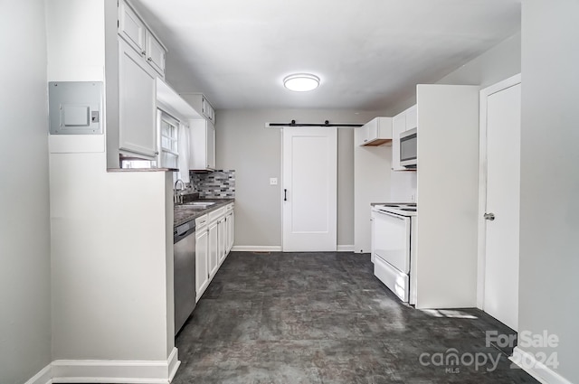 kitchen with sink, white cabinetry, a barn door, and stainless steel appliances