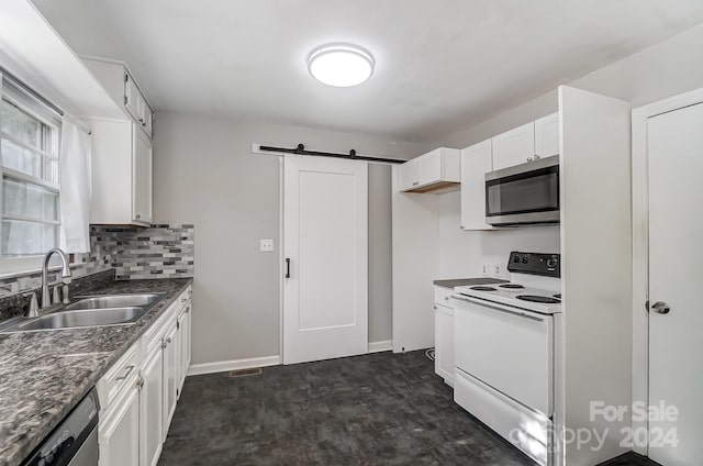 kitchen with stainless steel appliances, a barn door, tasteful backsplash, sink, and white cabinetry