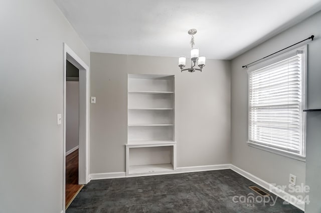 unfurnished dining area featuring dark wood-type flooring and an inviting chandelier