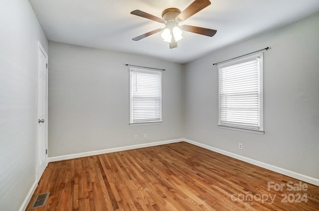 spare room with ceiling fan, hardwood / wood-style floors, and a healthy amount of sunlight