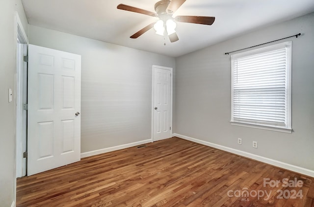 empty room with ceiling fan and wood-type flooring