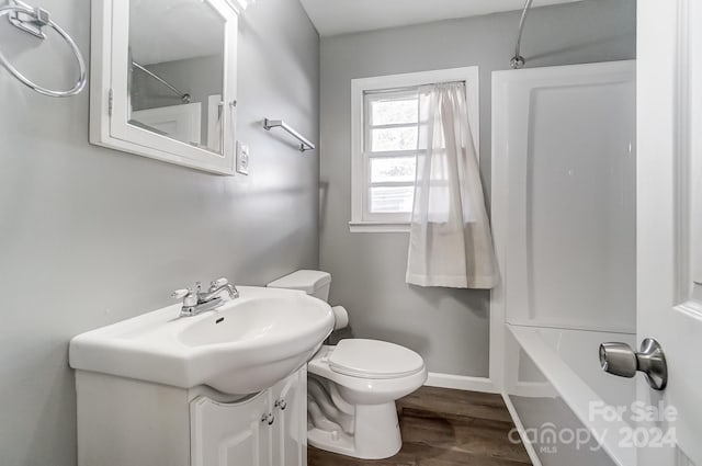 full bathroom with hardwood / wood-style flooring, shower / tub combination, vanity, and toilet