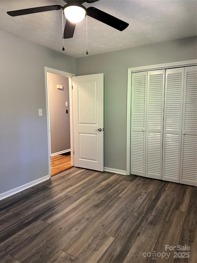 unfurnished bedroom with a closet, dark hardwood / wood-style floors, a textured ceiling, and ceiling fan