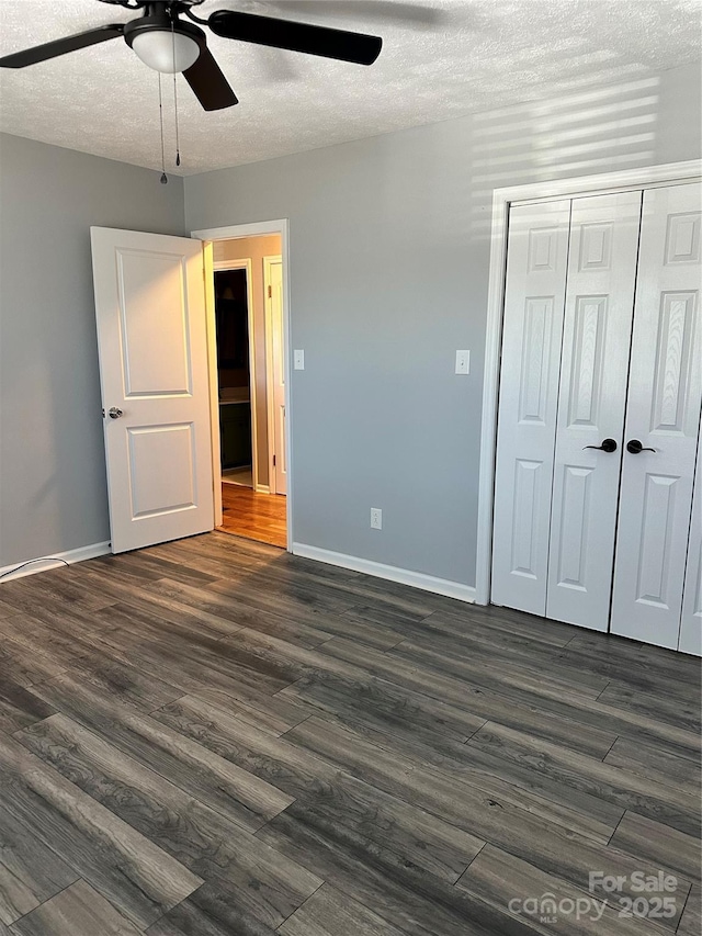 unfurnished bedroom with dark hardwood / wood-style flooring, ceiling fan, a closet, and a textured ceiling