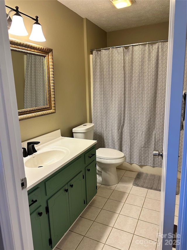 bathroom featuring vanity, toilet, tile patterned flooring, and a textured ceiling