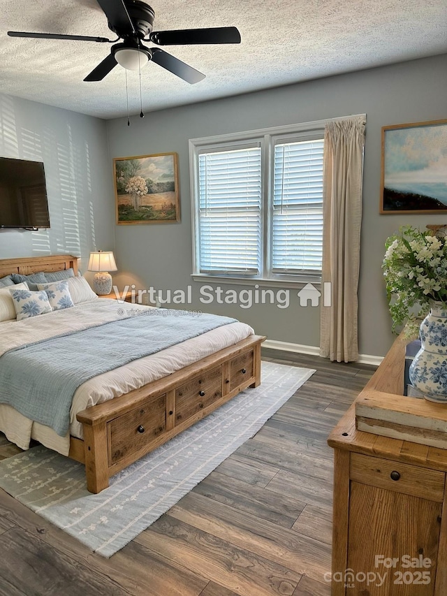 bedroom with ceiling fan, dark wood-type flooring, and a textured ceiling