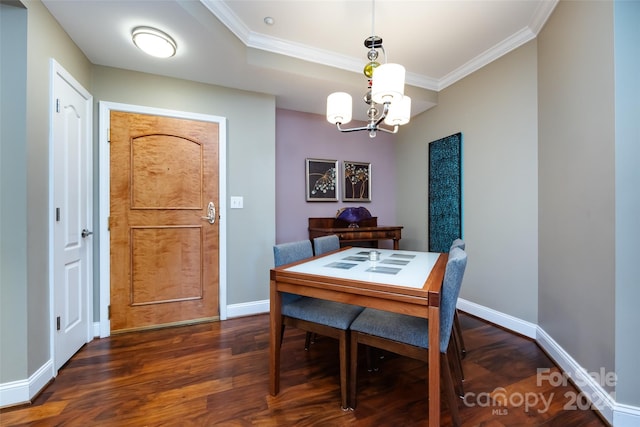 dining space with crown molding, dark hardwood / wood-style floors, and an inviting chandelier