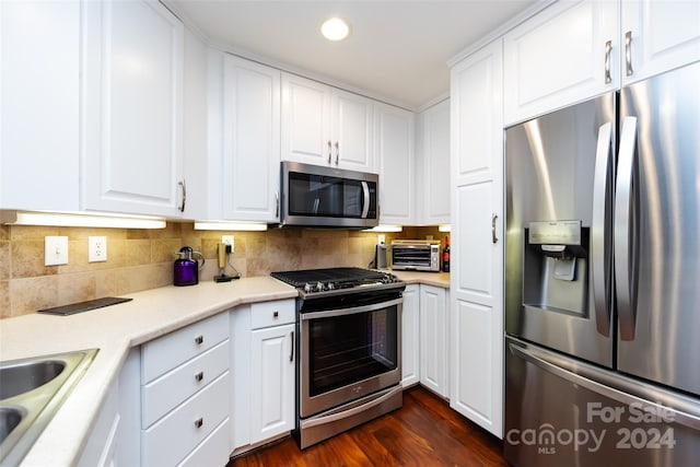 kitchen with decorative backsplash, appliances with stainless steel finishes, white cabinetry, and dark wood-type flooring