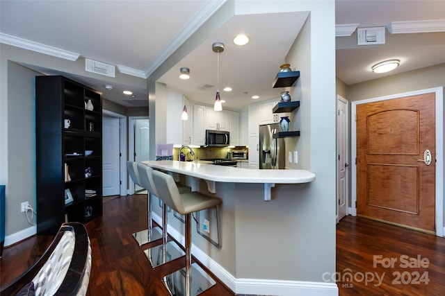 kitchen with a kitchen bar, appliances with stainless steel finishes, kitchen peninsula, dark hardwood / wood-style flooring, and white cabinets