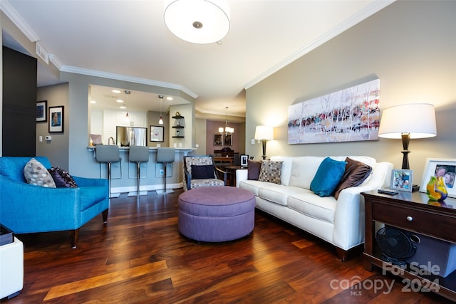 living room featuring dark hardwood / wood-style flooring, crown molding, and a notable chandelier