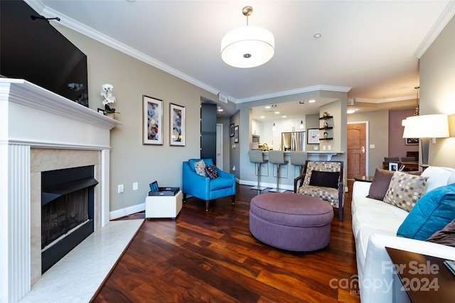 living room with hardwood / wood-style flooring, ornamental molding, and a fireplace