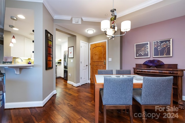 dining space featuring dark hardwood / wood-style floors, sink, crown molding, and an inviting chandelier