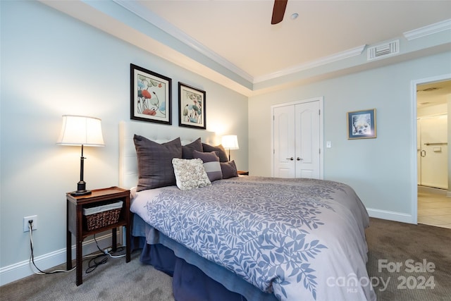 bedroom with carpet, ceiling fan, crown molding, and a closet