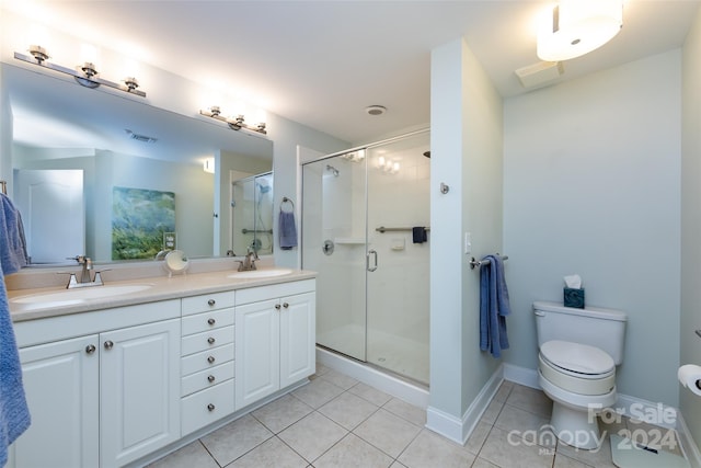 bathroom featuring tile patterned flooring, vanity, toilet, and walk in shower