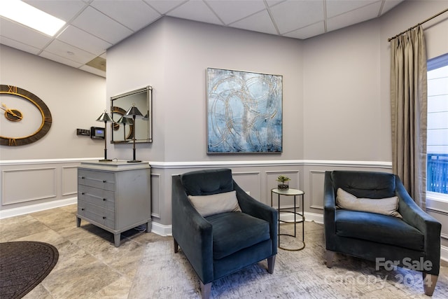 401 N Church St Unit 406, Charlotte, NC 28202 - living area featuring a drop ceiling, a decorative wall, and a wainscoted wall