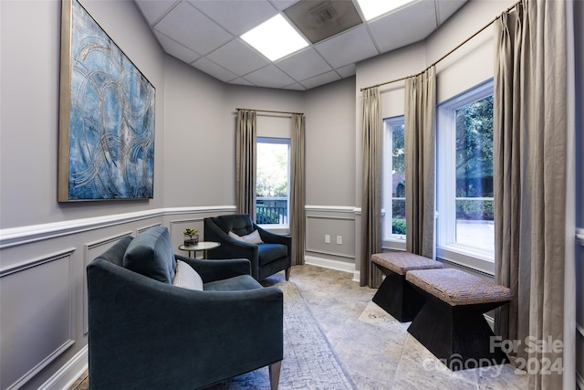 401 N Church St Unit 406, Charlotte, NC 28202 - living area featuring a decorative wall, healthy amount of natural light, wainscoting, and a paneled ceiling