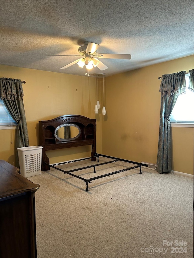 bedroom featuring a textured ceiling, ceiling fan, and carpet floors