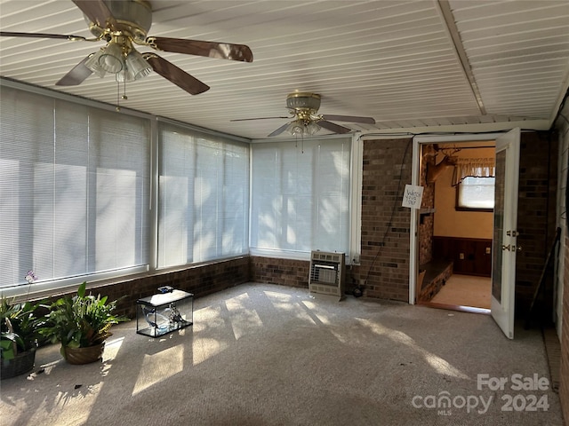 unfurnished sunroom featuring heating unit and ceiling fan