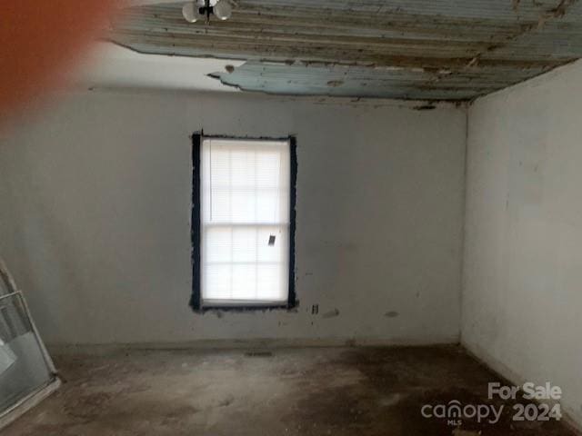 unfurnished room with concrete flooring