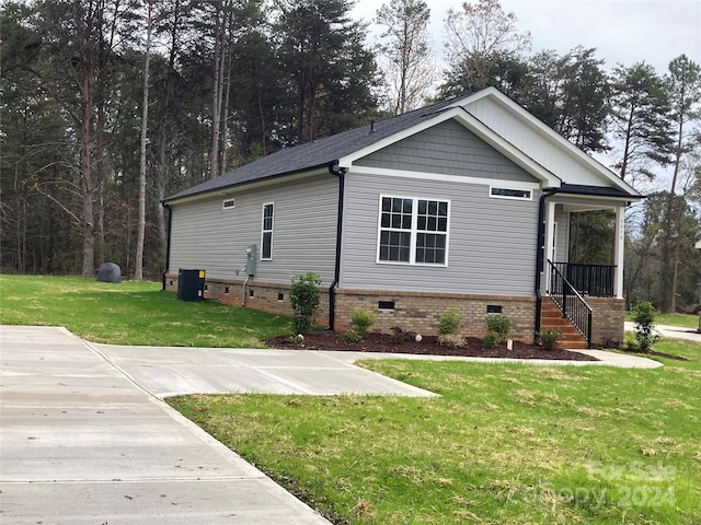 view of front of house featuring central air condition unit, a front lawn, and a porch