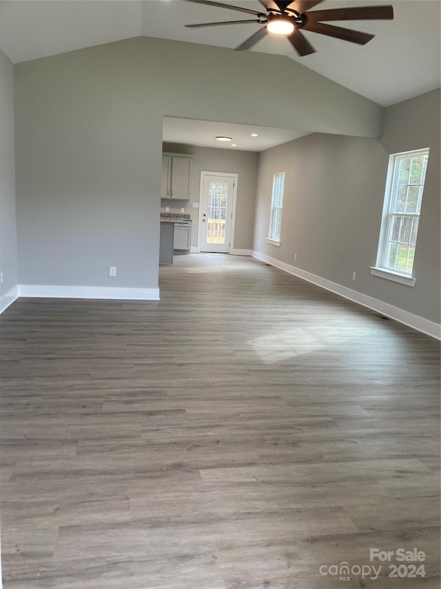 unfurnished living room with plenty of natural light, vaulted ceiling, and light hardwood / wood-style flooring