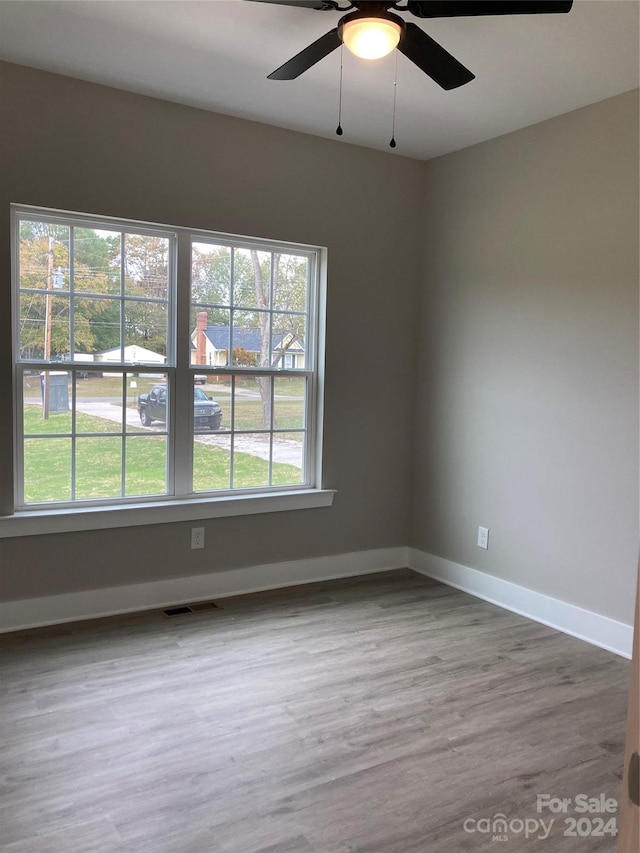 spare room with hardwood / wood-style floors and ceiling fan