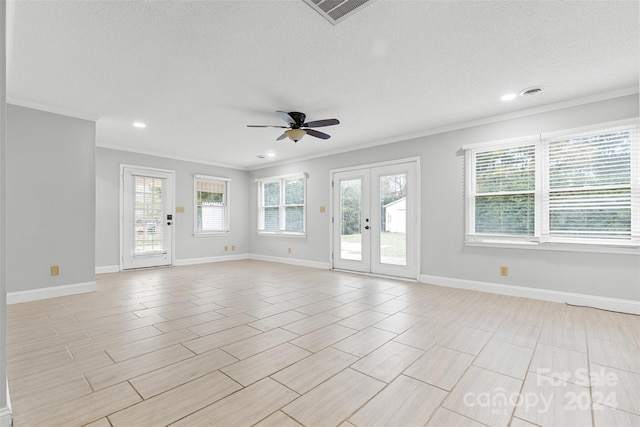 empty room featuring ceiling fan, french doors, a textured ceiling, and ornamental molding