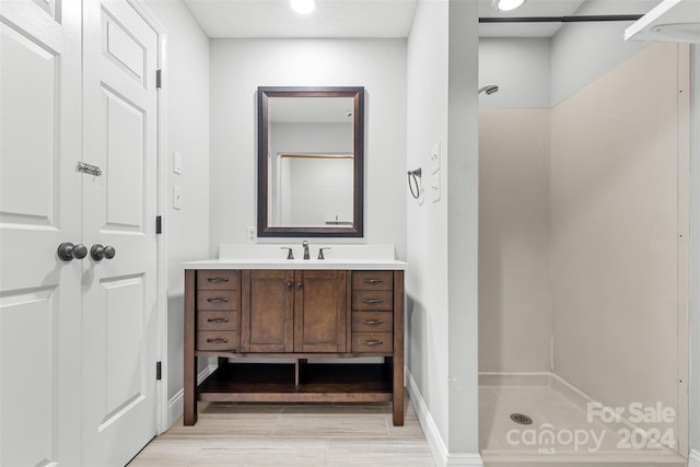 bathroom featuring a shower, wood-type flooring, and vanity