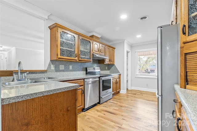 kitchen with backsplash, sink, light hardwood / wood-style flooring, ornamental molding, and stainless steel appliances