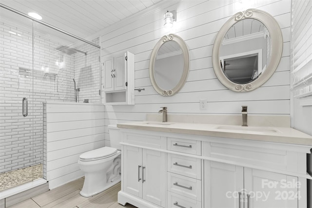 bathroom with vanity, a shower with door, hardwood / wood-style flooring, toilet, and wood walls