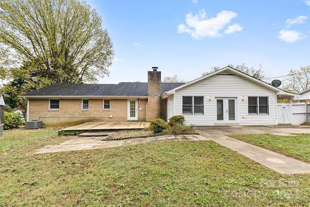 back of property with french doors, a yard, cooling unit, and a wooden deck