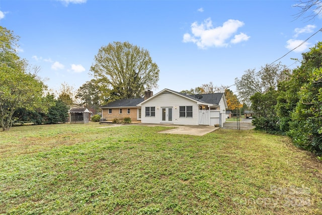 back of house with a patio area and a lawn